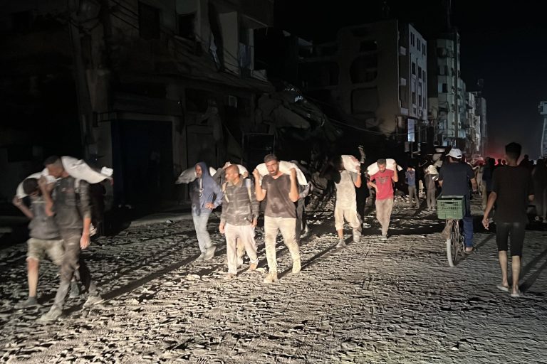 People carry their sacks of flour Flour they got from aid trucks in North Gaza Strip, where there is a food crisis due to Israeli attacks